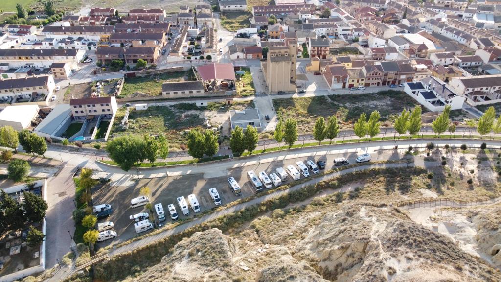Vista aérea de Arguedas: casco urbano, la iglesia y el aparcamiento de autocaravanas junto a los cortados de las Bardenas.